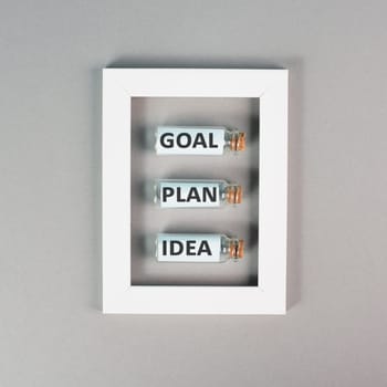 Three glass bottles with the words idea, plan and goal in a frame, education, marketing and business concept, brainstorming for new targets