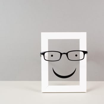 Frame with a happy face with eyeglasses, mental health concept, positive mindset and emotion, support and evaluation symbol