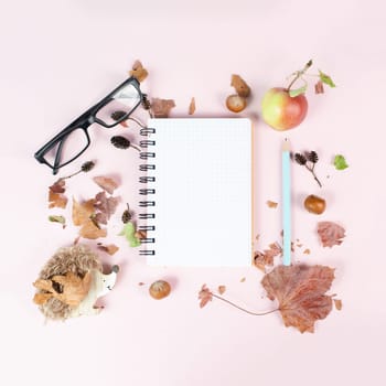 Empty notebook with an apple and a hedgehog, autumn template with colorful leaves, office desk, pastel color
