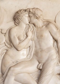 Ornamental relief of a fountain in Florence, Italy. Ancient sculpture with kissing couple. Florentine art 16th Cent.