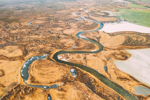 Belarus. Aerial View Of Dry Grass And Partly Frozen Curved River Landscape In Late Autumn Day. High Attitude View. Marsh Bog. Drone View. Bird's Eye View.