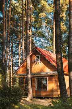 Tourist Guest House For Rest. Wooden House In Forest In Autumn Sunny Day.