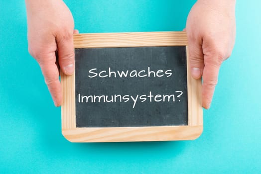 Weak immune system is standing in german language on a chalkboard, healthy eating and lifestyle concept, natural protection from disease
