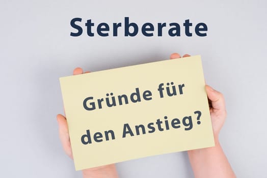 The german words for mortality rate, reasons for the increase are standing on the paper, covid-19 pandemic deaths, vaccine damage