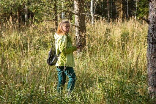 Woman play Geocaching. Walk in deep forest.