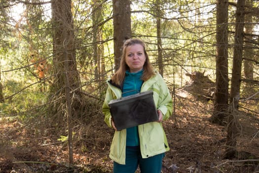 Woman find big metal box. Geocaching in the woods