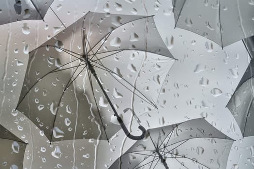 Superimposed images of raindrops and umbrellas as a representation of bad weather