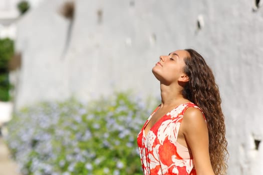 Profile of a woman in red breathing fresh air in a town street