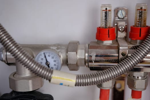 Heating system manifold valves for heat flooring and water supply in a country house. Pipes collector in a building under construction.