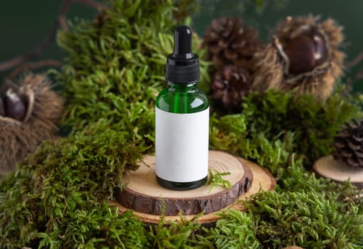 Green glass dropper bottle with blank label on wooden piece between green moss, close up, mockup. Skincare beauty product package. Natural Organic Cosmetic concept