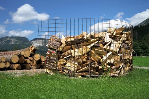 A large amount of firewood under a blue sky