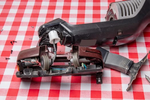 Repair of household appliances. Professional technician repairs a vacuum cleaner. Household appliances customer service. Battery hoover. Repair by a specialist on site.