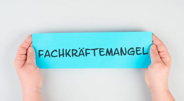 The word skills shortage is standing in german language on the paper, employees are missing, not enough workers