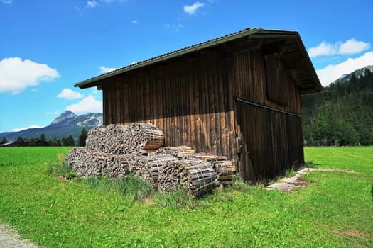 Wooden shed on a meadow under a blue sky