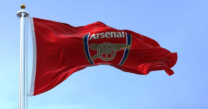 London, UK, May 2022: The flag of Arsenal Football Club waving in the wind on a clear day. Arsenal is a professional football club based in Islington, London, England