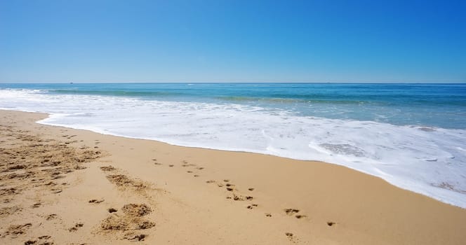 Sun Surf and Sandy Beach. A peaceful winter scene with surf waves rolling onto the beach at Kawana on the Sunshine Coast, Queensland, Australia.