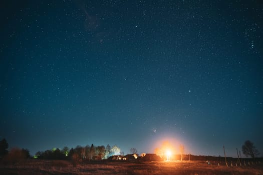 Real Night Sky Stars Above Old Village. Natural Starry Sky Above Rural Countryside Landscape In Belarus.