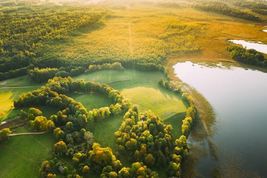 Aerial View Of Green Forest And Meadow Hill Landscape Near River. Top View Of Beautiful Nature From High Attitude. Bird's Eye View.