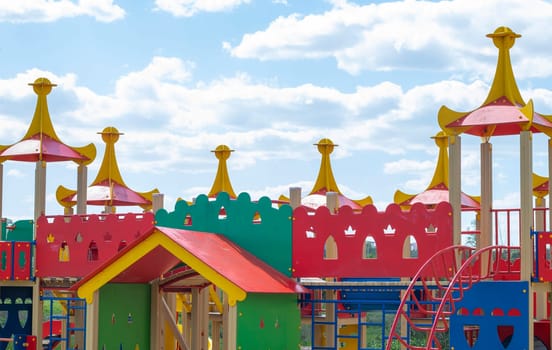 Modern public playground against the blue sky. A colorful play and sports complex for children without people. Equipment for rock climbing and assault on the playground