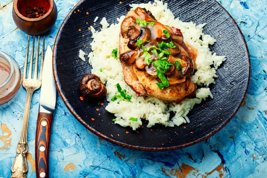Baked chicken breast with marsala mushroom sauce and rice.