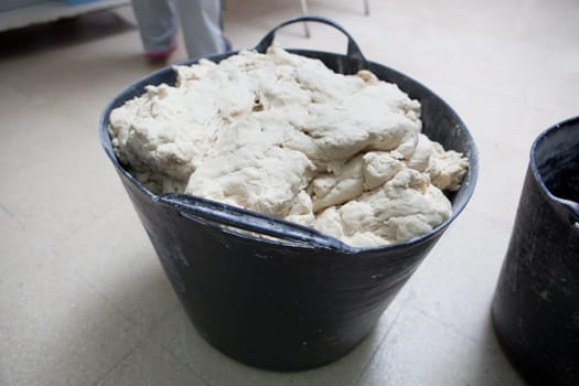 Bucket of dough for bread. Manufacturing process of spanish bread