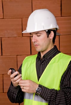 engineer with white hat with a brick wall as background