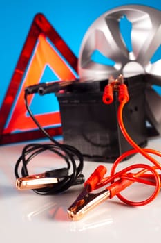 Car battery with two jumper cables clipped on vivid moto concept