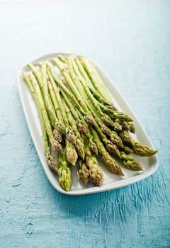 Bunch of fresh asparagus on a plate close up