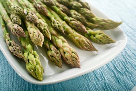Bunch of fresh asparagus on a plate close up