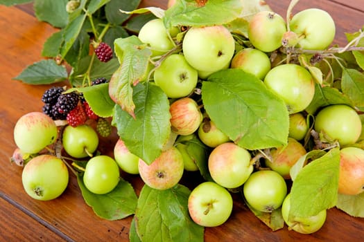 apples and raspberries on a wooden table