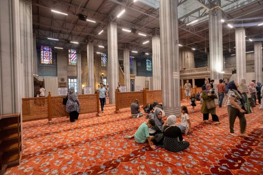Istanbul, Turkey - August 5, 2022: Interior of famous Sultan Ahmed blue mosque with with prayers, Istanbul, Turkey