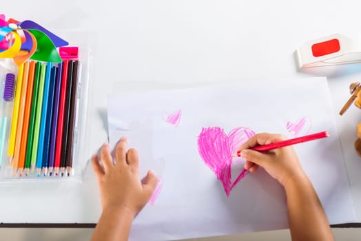 Asian cute kid preschool smiling draw creative hearts love picture at home, Happy child little girl colorful drawing pink heart on white paper, Valentine day or Mother or Fathers Day, art education