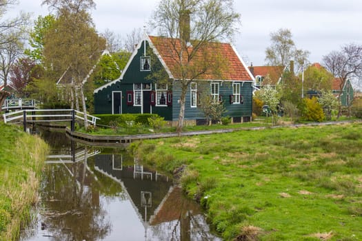 Traditional Houses reflecting in the Canal in the Historic Village of Zaanse Schans on the Zaan River in the Netherlands