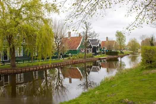 Traditional Houses reflecting in the Canal in the Historic Village of Zaanse Schans on the Zaan River in the Netherlands