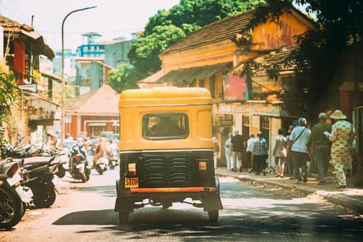 Panaji, Goa, India. Yellow Auto Rickshaw Or Tuk-tuk Moving On Street In Sunny Day.
