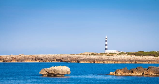 MINORCA ISLE - SPAIN - CIRCA AUGUST 2020: scenic Artrutx Lighthouse at sunset, famous landmark of the Isle