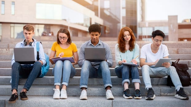 Multiracial Students Learning Preparing For End-Of-Semester Exams Together Sitting On Steps Outside University. College Lifestyle