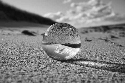 glass globe on the beach of the baltic sea. Black and white photograph