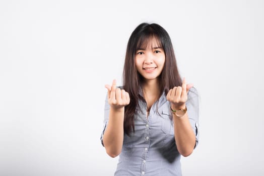 Woman standing her smile confidence showing mini heart sign with her finger isolated white background, Asian happy portrait beautiful young female send love and happy valentine in studio shot