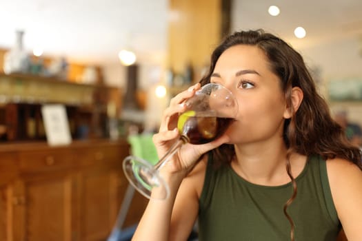Woman drinking soda refreshment sitting in a restaurant
