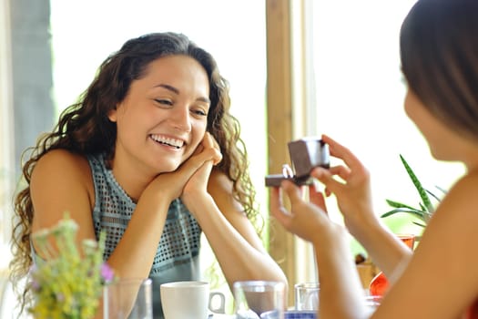 Marriage proposal of two happy lesbian women in a restaurant