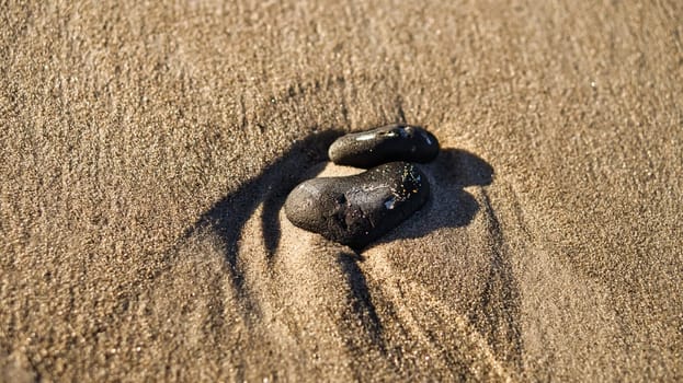 heart-shaped stone in the sand of the beach on the Baltic Sea. Romantic symbol for those in love. Small sign as still life.
