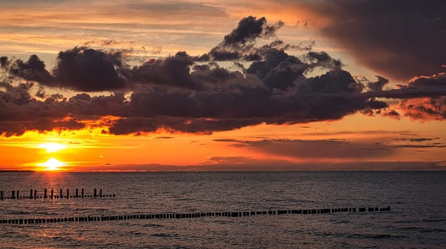 Sunset on the beach of the Baltic Sea in Zingst. Light mood with sun, clouds, sea and beach
