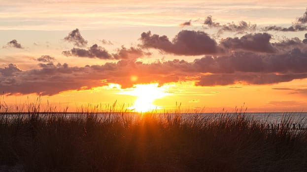 Sunset on the beach of the Baltic Sea in Zingst. Light mood with sun, clouds, sea and beach