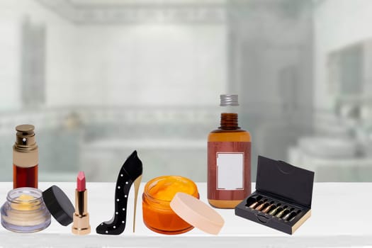 Decorative composition of various colorful beauty and makeup products on table over blurred bathroom background. Space for advertising and design. Serum for face, perfume, skin care and spa products.