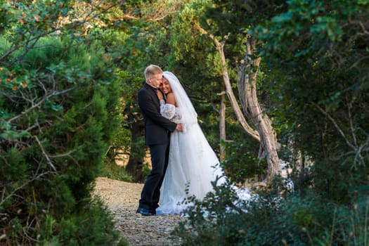 Interracial newlyweds hugging against the backdrop of a beautiful forest landscape