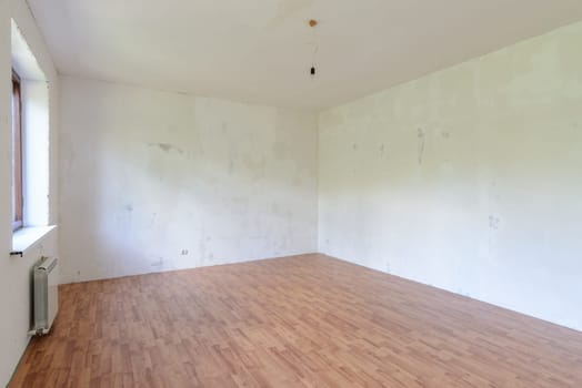 A fragment of the interior of a spacious empty room with a fine finish of the walls