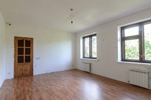 A fragment of a room with a fine finish, a view of the front door and windows