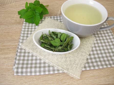 A cup of herbal tea with dried goutweed
