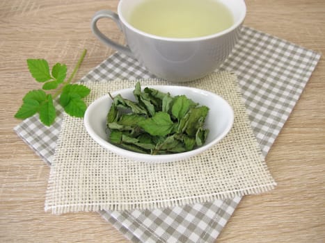 A cup of herbal tea with dried goutweed